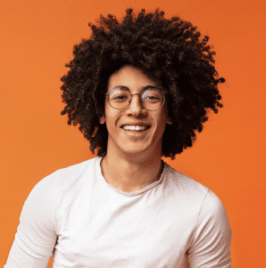 A smiling man with glasses and a stylish afro hairstyle, radiating positivity and good vibes.