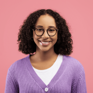 A young woman wearing glasses and a cozy purple sweater, smiling warmly at the camera.