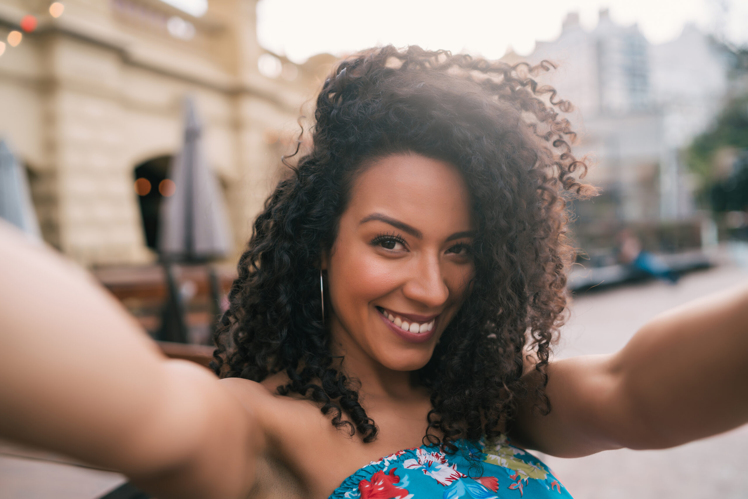 Portrait of young afro american woman taking a selfie outdoors in the street. Enjoying life. Lifestyle concept.