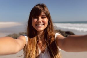 beautiful woman looking camera beach sunshine scaled