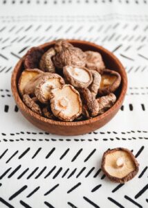 Chinese dried mushrooms Shiitake in a wooden bowl on a table. The concept of medicinal superfoods for health. Top view, flat lay.