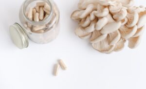 mushrooms and a bottle with mushroom capsules supplement